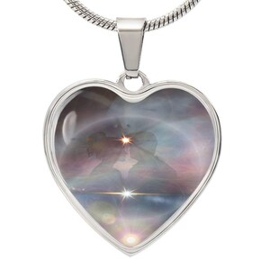 May include: A silver heart-shaped necklace featuring a colourful image of a couple silhouetted against a starry sky. The image is surrounded by a silver border.