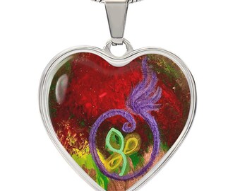 Könnte beinhalten: Ein herzförmiger Anhänger mit einer silbernen Kette. Der Anhänger zeigt ein lebendiges abstraktes Design mit roten, grünen, gelben und violetten Farben. Das Design ist in einem silbernen Rahmen eingefasst.