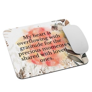 May include: A mouse pad with a watercolor background featuring a quote that reads: "My heart is overflowing with gratitude for the precious moments shared with loved ones."