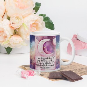 May include: White ceramic mug with a celestial design featuring a crescent moon, stars, and watercolor clouds. The mug has the text "I am the architect of my destiny, and I choose to build a life filled with happiness and success."