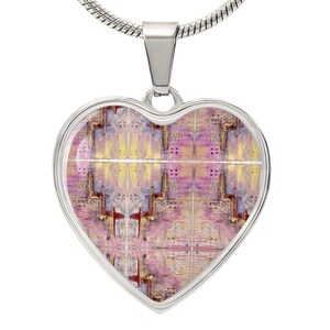 Peut inclure: Un collier avec un pendentif en forme de cœur argenté orné d'un motif abstrait coloré. Le motif présente des nuances de rose, de jaune et de bleu.