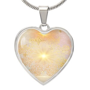 May include: A silver heart-shaped pendant necklace with a gold mandala design on a white and pink background. The pendant is on a silver chain.