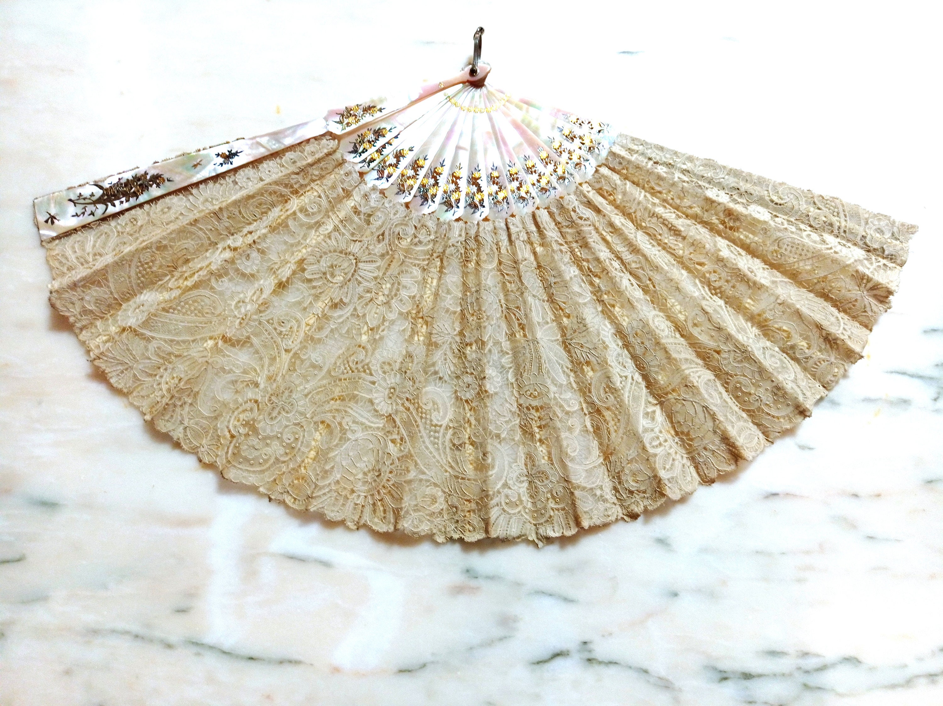 An Edwardian mother-of-pearl and Brussels lace folding hand fan