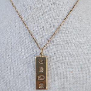 A vintage gilded sterling silver ingot pendant