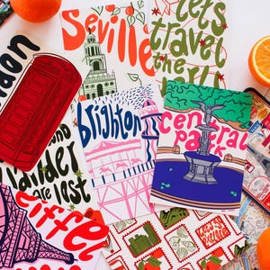 May include: A selection of travel-themed postcards and stickers, including designs of a red telephone box, the Eiffel Tower, and Central Park. The image also features oranges and a map. Phrases like "London" and "Let's travel the world" are visible.