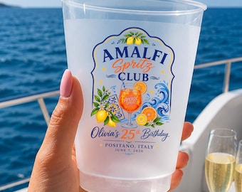 May include: A clear plastic cup featuring a colorful graphic with the text Amalfi Spritz Club, Olivia's 25th Birthday, Positano, Italy, June 7, 2026. The design includes illustrations of lemons, orange slices, a cocktail glass, and blue waves.