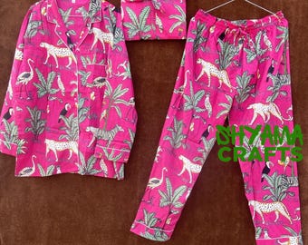 May include: Pink pajama set with a tropical print featuring leopards, toucans, and palm trees. The set includes a long-sleeved shirt with a button-up front and matching pants.