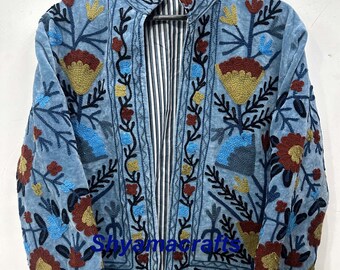 May include: A light blue jacket with intricate floral embroidery in shades of red, yellow, and blue. The jacket features a high collar and a striped lining. The embroidery is detailed and covers the front and sleeves.