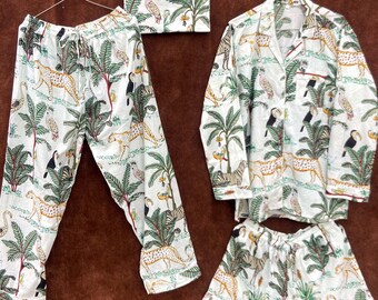 Puede incluir: Conjunto de pijama blanco con estampado de jungla que presenta leopardos, tucanes y palmeras. El conjunto incluye pantalones, una camisa de manga larga y pantalones cortos. Los pantalones y pantalones cortos tienen cintura con cordón.