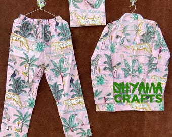 May include: Pink pajama set with a jungle print featuring toucans, zebras, leopards, and palm trees. The set includes a long-sleeved shirt with a button-up front and matching pants.