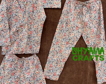 May include: A pajama set with a paisley print in shades of pink, blue, and white. The set includes a long-sleeved shirt, pants, and shorts.