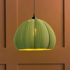 Illuminated lamp shade shown in Olive colour.