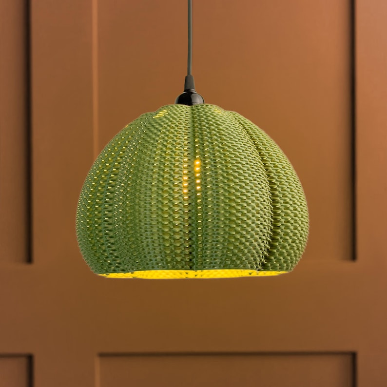 Illuminated lamp shade shown in Olive colour.