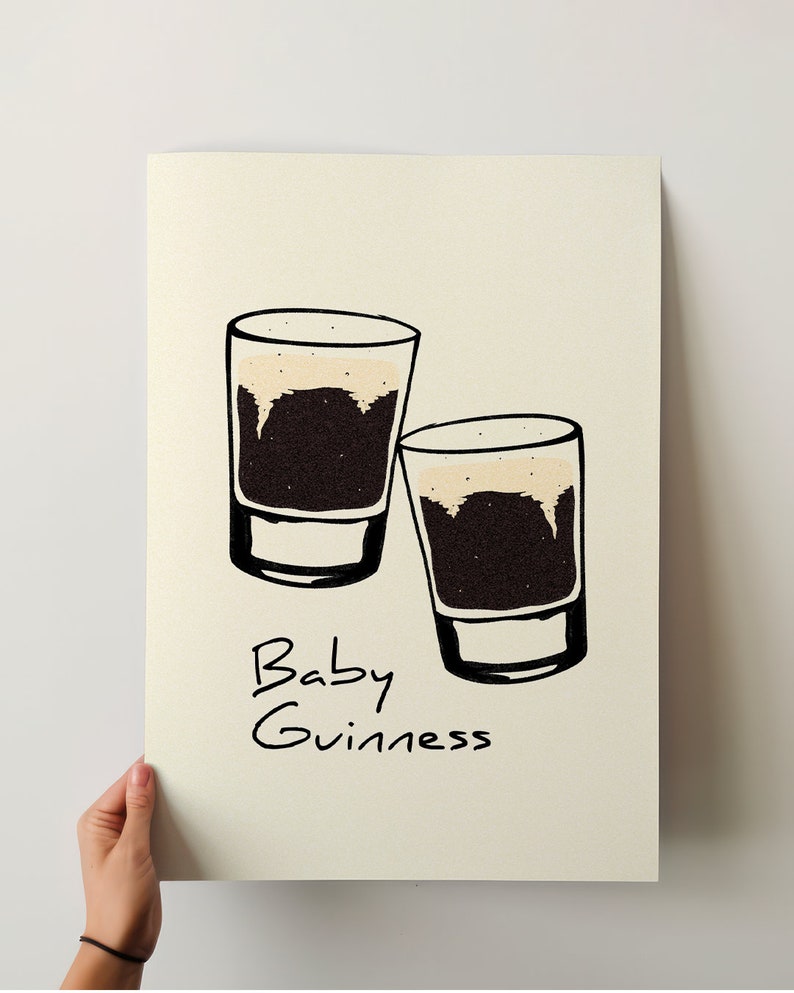 May include: Two small glasses filled with a dark brown liquid topped with a light brown foam. The text "Baby Guinness" is written below the glasses.