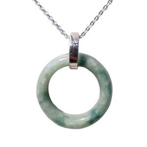 Puede incluir: Un collar de cadena de plata con un colgante de anillo de jade verde. El anillo es liso y tiene un acabado pulido.
