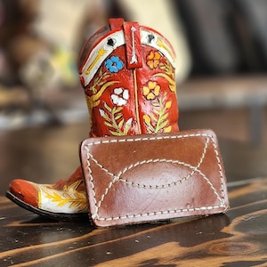 Brown leather belt buckle with a western stitch pattern