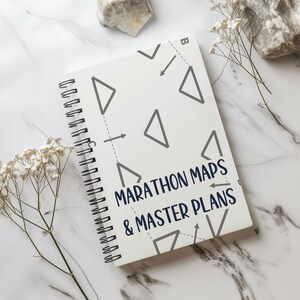 Puede incluir: Una libreta de espiral blanca con un patrón geométrico gris y el texto "MARATHON MAPS & MASTER PLANS" en azul.