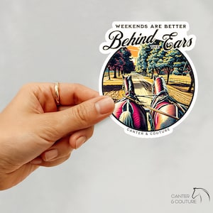 May include: A sticker featuring the text "Weekends are Better Behind the Ears" and an illustration of horses pulling a carriage along a tree-lined road. The sticker also includes the text "Canter & Couture".