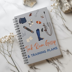 Puede incluir: Cuaderno de espiral gris con el texto "Tack Room Gossip & Training Plans" en naranja y azul. La portada presenta ilustraciones de equipo ecuestre, incluyendo una silla de montar, botas y una fusta.