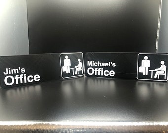 May include: Three black office door signs with white text and icons. The signs read "Jim's Office", "Michael's Office", and a third sign with an icon of two stick figures.