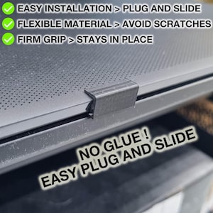 Puede incluir: Primer plano de una tapa de portátil negra con un clip de plástico negro. El texto "NO GLUE! EASY PLUG AND SLIDE" es visible en la imagen. La tapa del portátil tiene un patrón de pequeños agujeros.
