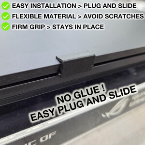 Könnte beinhalten: Schwarzes Kunststoffzubehör für einen Laptop mit einfachem, eckigem Design. Der Text auf dem Bild lautet: "EINFACHE INSTALLATION > PLUG AND SLIDE", "FLEXIBLES MATERIAL > VERMEIDET KRATZER" und "FESTER HALT > BLEIBT AN ORT UND STELLE". Der Text "NO GLUE! EASY PLUG AND SLIDE" ist ebenfalls sichtbar.