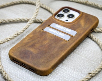 May include: A brown leather phone case with two card slots. The case has a distressed look and the words "CREDIT CARD" are printed on the card slots.