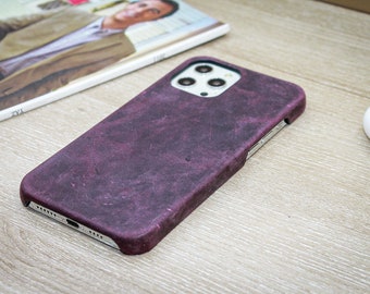 Può includere: Una custodia per telefono viola realizzata in materiale testurizzato. La custodia ha un rialzo per la fotocamera rialzato con tre obiettivi.