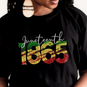 May include: Black t-shirt with a glittery red, yellow, and green design that says "Juneteenth 1865".