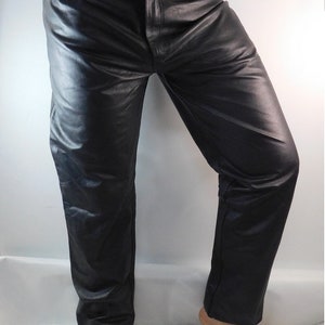 May include: Black leather pants with a classic five-pocket design. The pants have a straight leg cut and a button and zipper closure. The leather appears to be smooth and has a slight sheen. The pants are shown from the waist down.