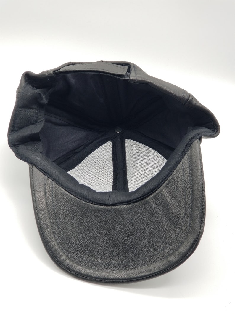 K&ouml;nnte beinhalten: Schwarze Baseballkappe aus Leder mit Mesh-Futter. Die Kappe hat einen gebogenen Schirm und einen schwarzen Riemen.