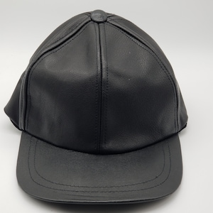 K&ouml;nnte beinhalten: Eine schwarze Baseballkappe aus Leder mit einem gebogenen Schirm.