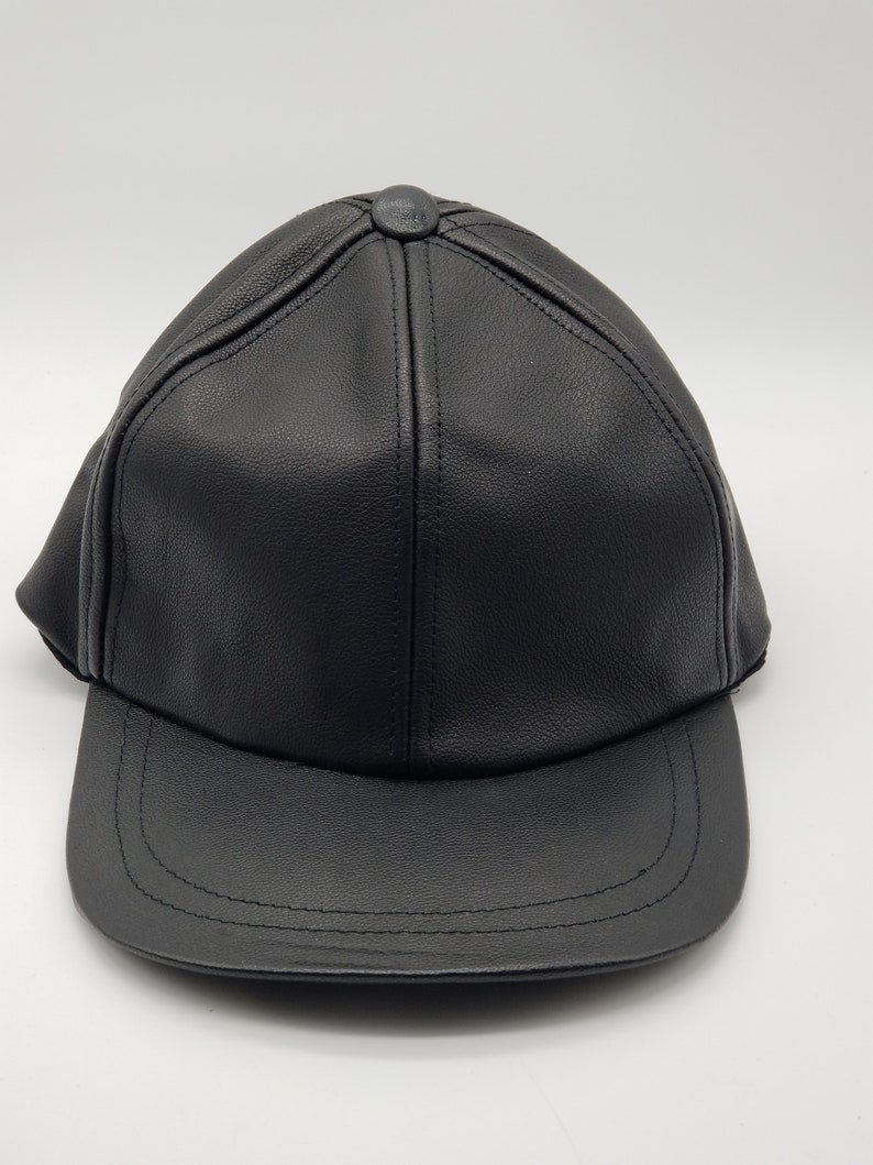 K&ouml;nnte beinhalten: Eine schwarze Baseballkappe aus Leder mit einem gebogenen Schirm.
