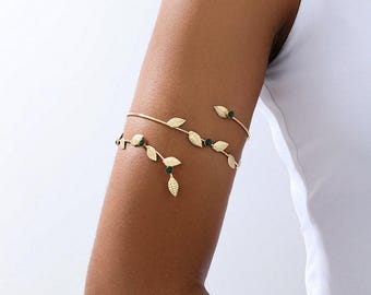 Brazalete tipo hoja dorada, ajustable, estilo bohemio, con detalles de cristal y piedras inspiradas en la naturaleza. Ideal como regalo para festivales y verano.