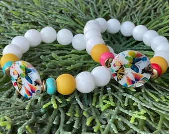 Handmade. High quality natural gemstones enhanced by natural shell focal bead adorned with vibrant, colorful butterflies.