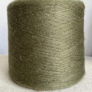 May include: A skein of soft, green yarn with a fuzzy texture.