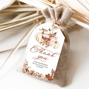 May include: A white thank you tag with a watercolor illustration of pumpkins and fall foliage. The tag says "Thank you" in calligraphy and "For showering Olivia with love 26.03.2023".