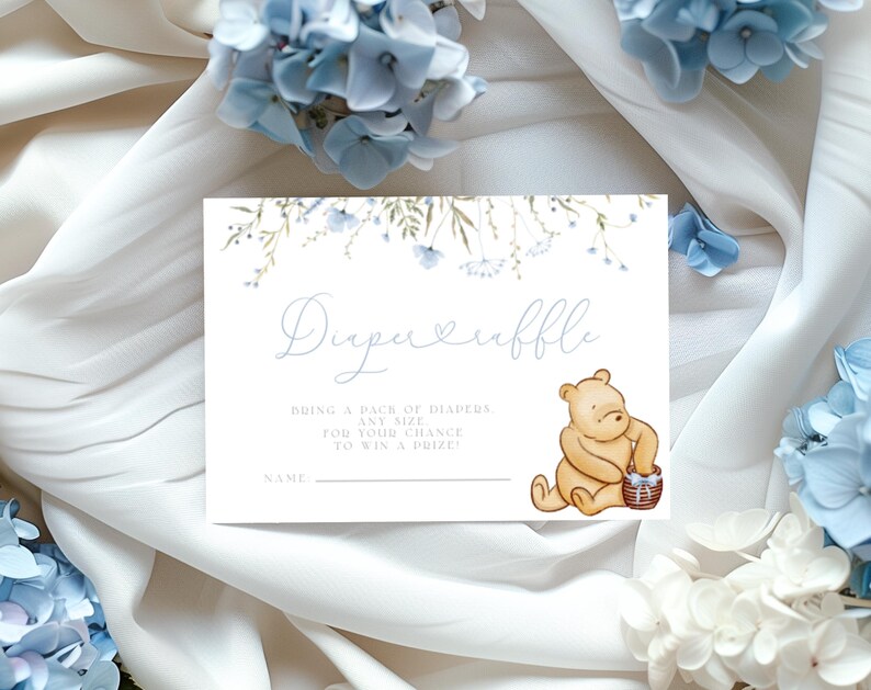 Pu&ograve; includere: Un biglietto bianco con disegni floreali blu e un'illustrazione di Winnie the Pooh. Il biglietto dice "Diaper Raffle" e "Porta un pacchetto di pannolini di qualsiasi taglia per avere la possibilit&agrave; di vincere un premio".
