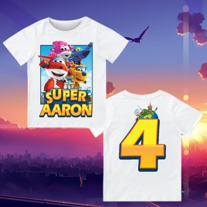 May include: White t-shirt with a colorful cartoon image of a plane and other characters. The text 'SUPER AARON' is printed below the image. The back of the shirt has a large yellow number 4 with a globe image inside the number.