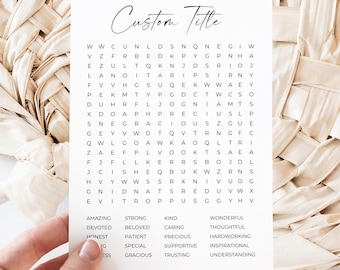 Puede incluir: Una tarjeta blanca con un juego de búsqueda de palabras y el texto "Custom Title" en una fuente manuscrita. La tarjeta se sostiene contra un fondo beige tejido. El rompecabezas incluye palabras como "amazing" y "devoted".