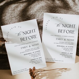 Puede incluir: Dos invitaciones de boda blancas con texto negro elegante. Las invitaciones dicen "The Night Before" e incluyen detalles para una cena de ensayo en honor a Emily & Noah. Flores secas se colocan cerca de las invitaciones.