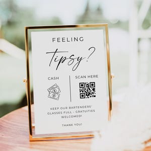 May include: A gold-framed sign with the text "FEELING Tipsy?" and "CASH" and "SCAN HERE" instructions. The sign also includes the text "KEEP OUR BARTENDERS' GLASSES FULL - GRATUITIES WELCOMED! THANK YOU!"