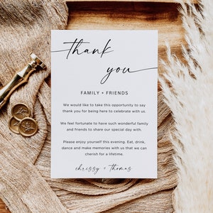 Puede incluir: Una tarjeta blanca con texto negro que dice "Gracias" en cursiva. La tarjeta tambi&eacute;n dice "Familia + Amigos" e incluye un mensaje agradeciendo a los invitados por asistir a la boda y celebrar con la pareja. La tarjeta est&aacute; firmada "chrissy + Thomas".
