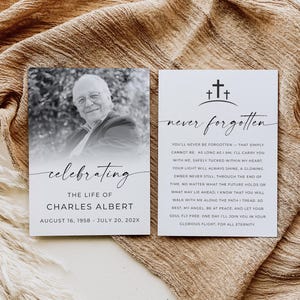 May include: Two memorial cards on a textured beige surface. One card features a black and white photo of a man and the word "celebrating". The other card has the words "never forgotten" and a poem.