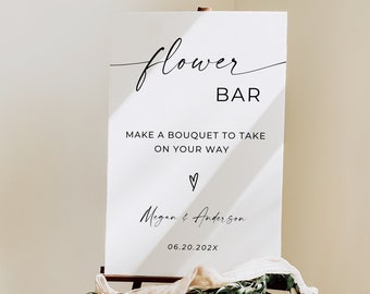 May include: White sign with black text that reads "flower bar" and "Make a bouquet to take on your way." Below the text is a heart symbol and the names "Megan & Anderson" and the date "06.20.202X".