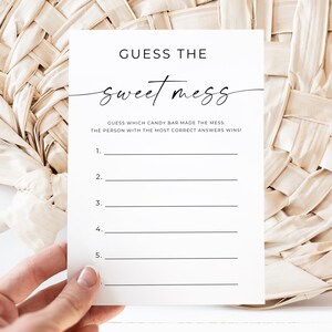 Może przedstawiać: Biała karta z czarnym tekstem "GUESS THE sweet mess". Karta ma linie do gry, trzymana na tle tkanej beżowej. Tekst wyjaśnia zasady gry.