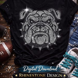 Pode incluir: Camiseta preta com decote em V com um design de strass do rosto de um buldogue. O design é feito de pedras brancas e pretas. O design digital mede 28,4 cm x 29,7 cm.
