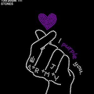 May include: A purple rhinestone heart with a white rhinestone hand gesture, known as the "mini heart" or "finger heart", with the text "I love you" in rhinestones.