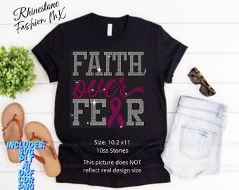 Könnte beinhalten: Schwarzes T-Shirt mit den Worten "FAITH OVER FEAR" in Strassbuchstaben und einem rosa Schleifendesign. Das Shirt enthält den Text "Rhinestone Fashion MX" und "Größe: 26 x 28 cm".
