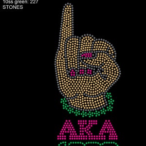 May include: A black background with a tan, pink, and green rhinestone design of a hand pointing up with the letters "AKA" and the year "1908" below.